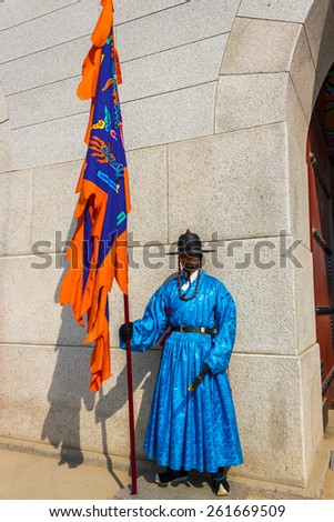 SEOUL, KOREA - MARCH 8, 2015: guard stands at the entry gate of Gyeongbokgung Palace, the old royal residence, in Seoul, South Korea on march 8, 2015