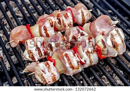 Raw skewers, graded and placed on the grill to be cooked.