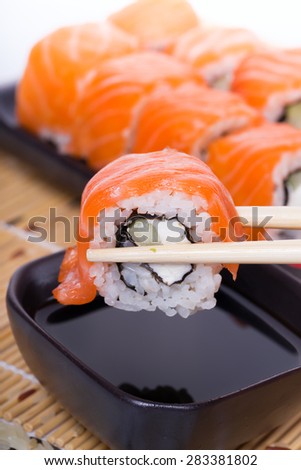 Salmon sushi rolls on a wooden background