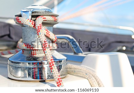 Sailing boat winch with red rope closeup