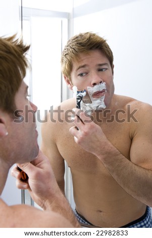 Man looking in the mirror shaving