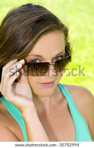 Young girl peeking over her sunglasses