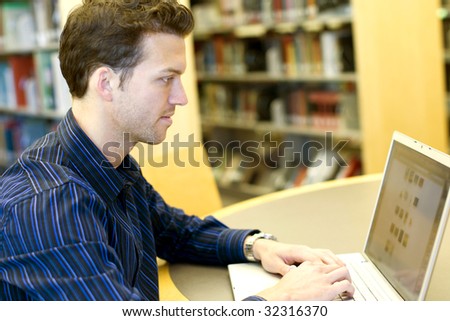Nice young man researching information on a laptop