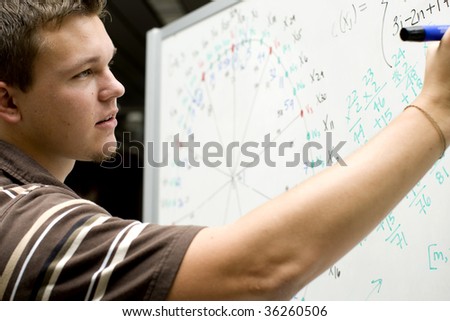 Young man at school doing a math equation