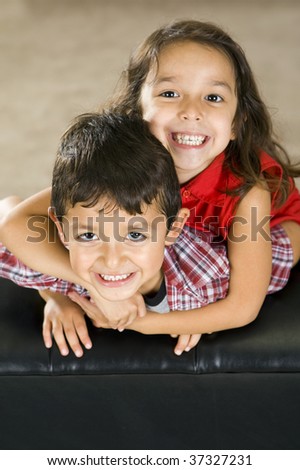 Cute brother and sister sitting on a couch