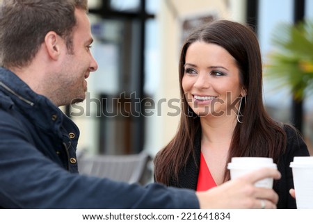 Young couple drinking coffee outside