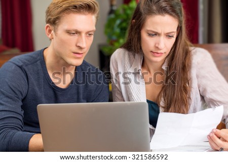 Stressed frustrated couple going over bills