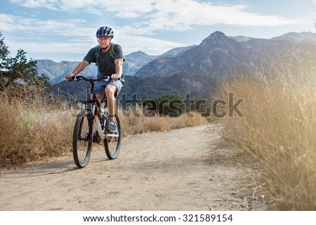 Man mountain biking wearing a water backpack
