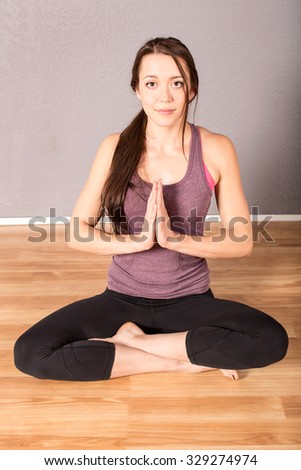 Woman in beginning yoga pose in a studio