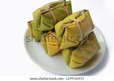 Thai style dessert on Plate, made from banana and glutinous rice, wrap with banana leaf