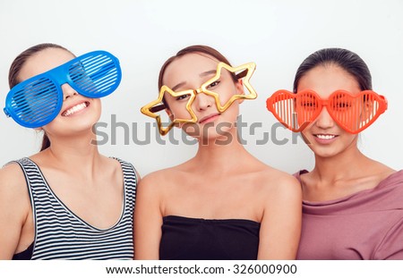 Asian girls in the funny sunglasses. They pose, grimace and look at the camera. Hair removed. The skin is clean.