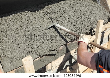 Worker pouring concrete to formwork at construction site