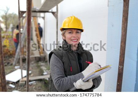 Construction inspector examine styrofoam insulation of house facade