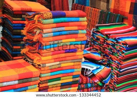 Piles of colorful woven fabric at a craft market in San Cristobal de las Casas, Chiapas, Mexico.