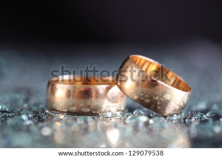 Gold wedding rings between drops