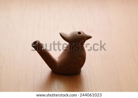 clay whistle in the bird shape on table