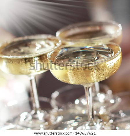 Three glasses of champagne with lights in the background.