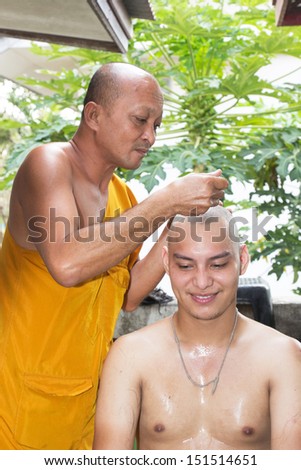 BANGKOK, THAILAND - March 03 : Thai man gets his head shaved by a monk during a Buddhist ordination ceremony on March 03, 2013 in Bangkok, Thailand.