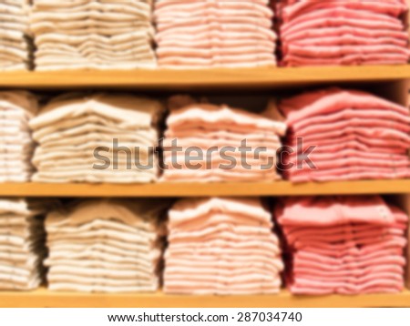 blurred abstract background of multicolored cotton clothing on the shelves of fashion shop.