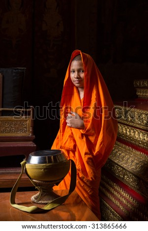 BANGKOK THAILAND - May 12 : Little Buddhist monk or novice he smile and covered his head by robe at Wat dusit temple, Bangkok, Thailand on May 12, 2015