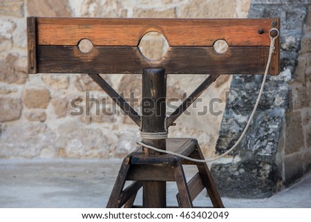 Old wooden pillory close up on castle stone wall background Stockfoto © 