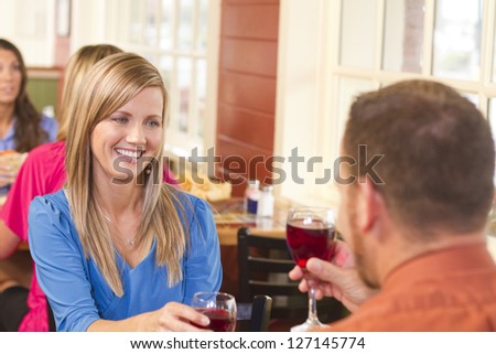 A happy couple out at a restaurant, toasting wine.
