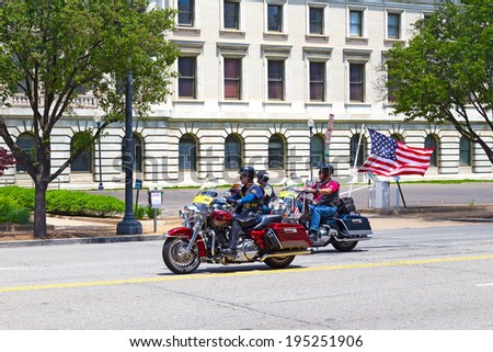 WASHINGTON, DC, USA - MAY 25, 2014: Harley Davidson colorful motorcycles travel on Independence Avenue under American flag. Rolling Thunder rally is the annual Memorial Day event in Washington, DC.