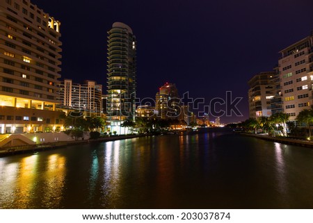 Miami Beach city landscape at night. Modern buildings along the waterfront with colorful reflections.