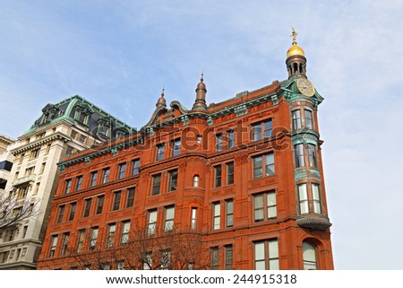 Historic SunTrust building with the clock tower in Washington DC downtown. Historic red brick building with gold-domed clock tower bearing ornamentation.
