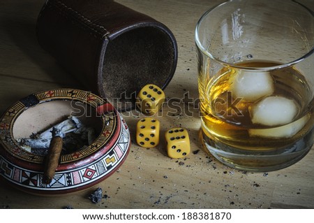 Dice game with cigar and alcoholic beverage.