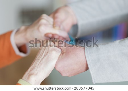 Young woman holding both hands a senior women.