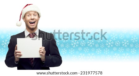 smiling young business man in santa hat holding sign over winter snowflakes background