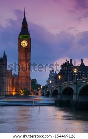 A beautiful sunset view of Big Ben and Westminster Bridge with a boat passing by