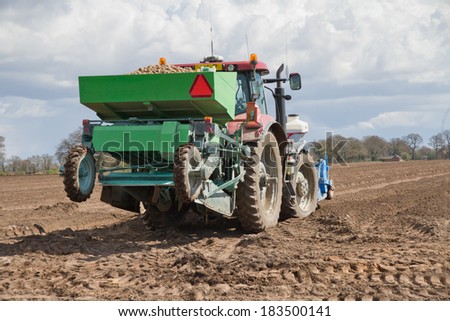Tractor planting potatoes in rural Shropshire, UK.