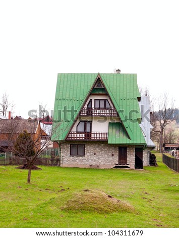 House with green roof and stone cladding