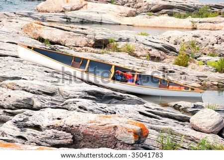 White canoe on rocky shore