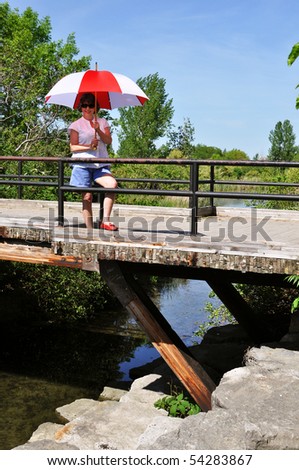 Lady with an umbrella on a bridge