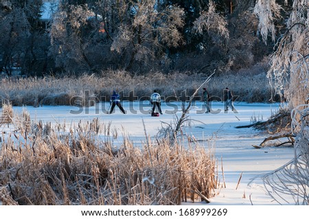 RICHMOND HILL, ONTARIO - DECEMBER 23: Group of teenagers playing hockey on a frozen pond on December 23, 2013 in Richmond Hill, Ontario, Canada.