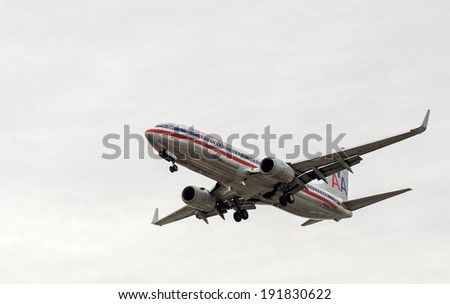 TORONTO INTERNATIONAL AIRPORT - MAY 9, 2014: American airlines jetliner with engaged landing gear landing at Toronto Pearson International airport.