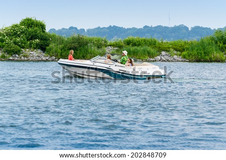 ORILLIA, ONTARIO - JUNE 29, 2014: Family in a sporty power boat, cruising the Lake Couchiching in the Orilia Harbor in Ontario,