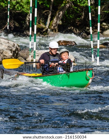 MINDEN, ONTARIO - SEPTEMBER 6, 2014: Father and son paddling at 2014 Open Canoe Slalom Race at Gull River in Minden, Ontario, Canada.