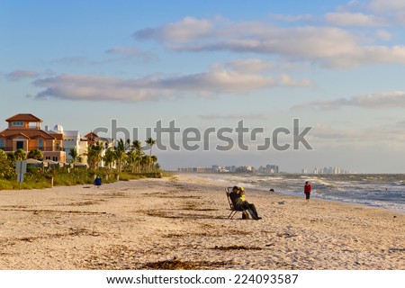 NAPLES, FLORIDA - NOVEMBER 4, 2011: Tourists enjoying the beach in Naples, Florida. Naples is located on the Gulf Coast in southern Florida.