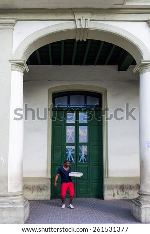 HAVANA - FEB 13:  African American man delivering a package in front of a building in Old Town of Havana on February 13, 2015.