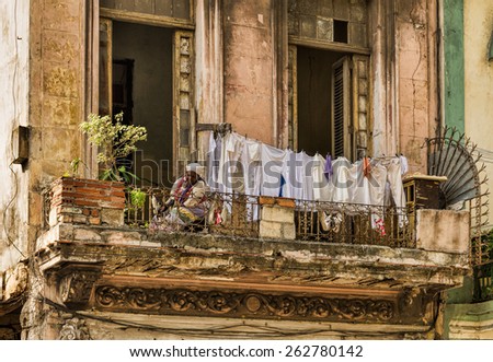 HAVANA - FEB 13:An elderly woman photographed on her balcony with a cloth line in an old apartment building in Old Town of Havana on February 13, 2015.