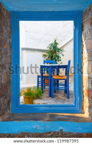 View of a traditional tavern table threw a window in  in Santorini island Greece