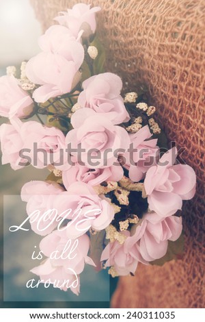 Love is all around. Quote about love on flower background.