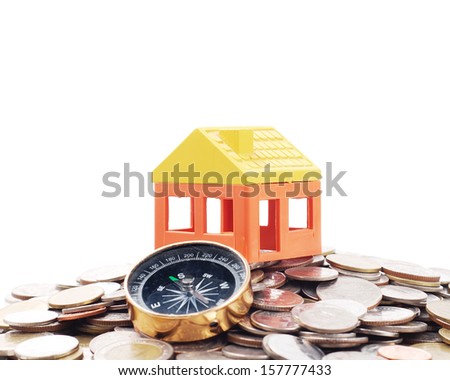 House model and compass on the way of coins