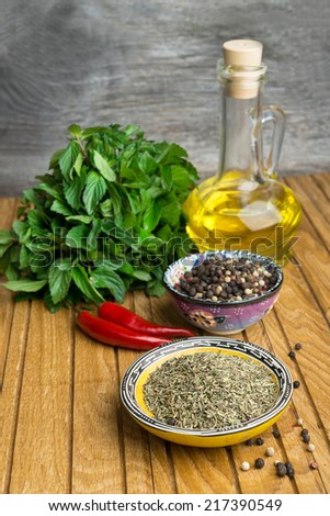 spices on cup, mint and oil  on old wooden table background