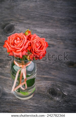 Pink roses  in a vase on wooden desk