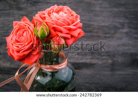 Close up pink roses  in a vase on wooden desk